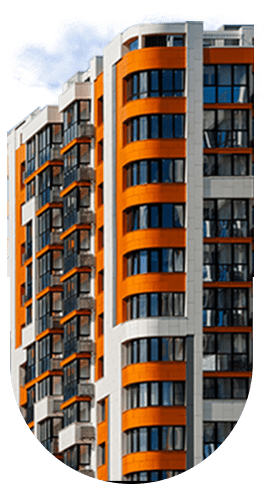 Modern multifamily apartment building with curved balconies, large windows, and orange and white exterior design