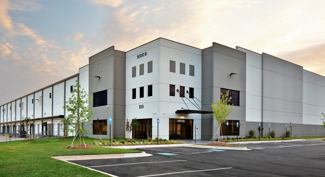 Modern commercial warehouse property with restored parking lot, landscaped grounds, and marked parking spaces